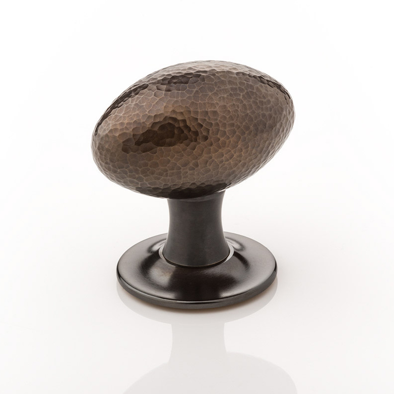 Intricately hammered solid brass oval door knob with tapered rose