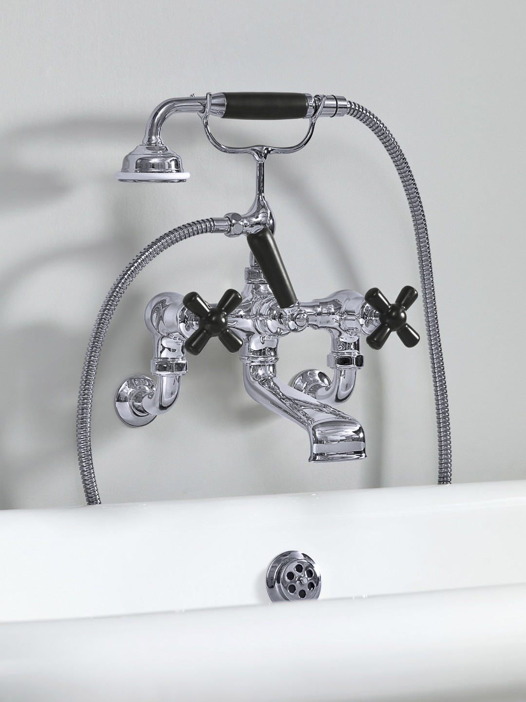 Rockwell wall-mounted bath mixer with handshower & metal/coloured crosshead taps