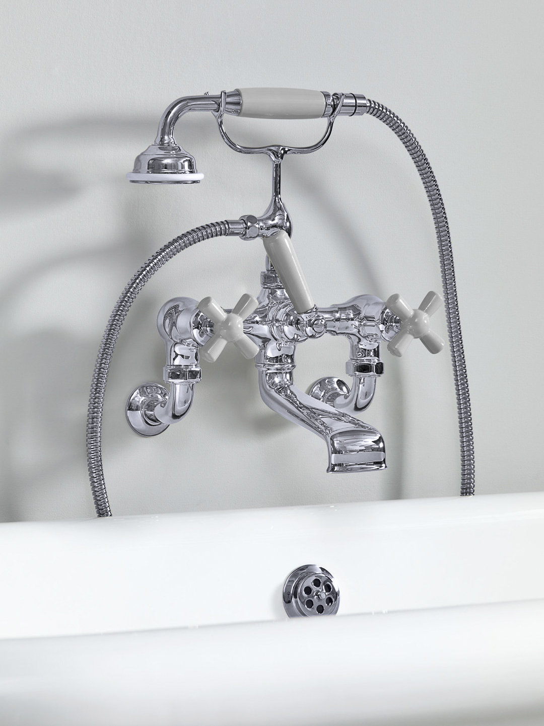 Rockwell wall-mounted bath mixer with handshower & metal/coloured crosshead taps