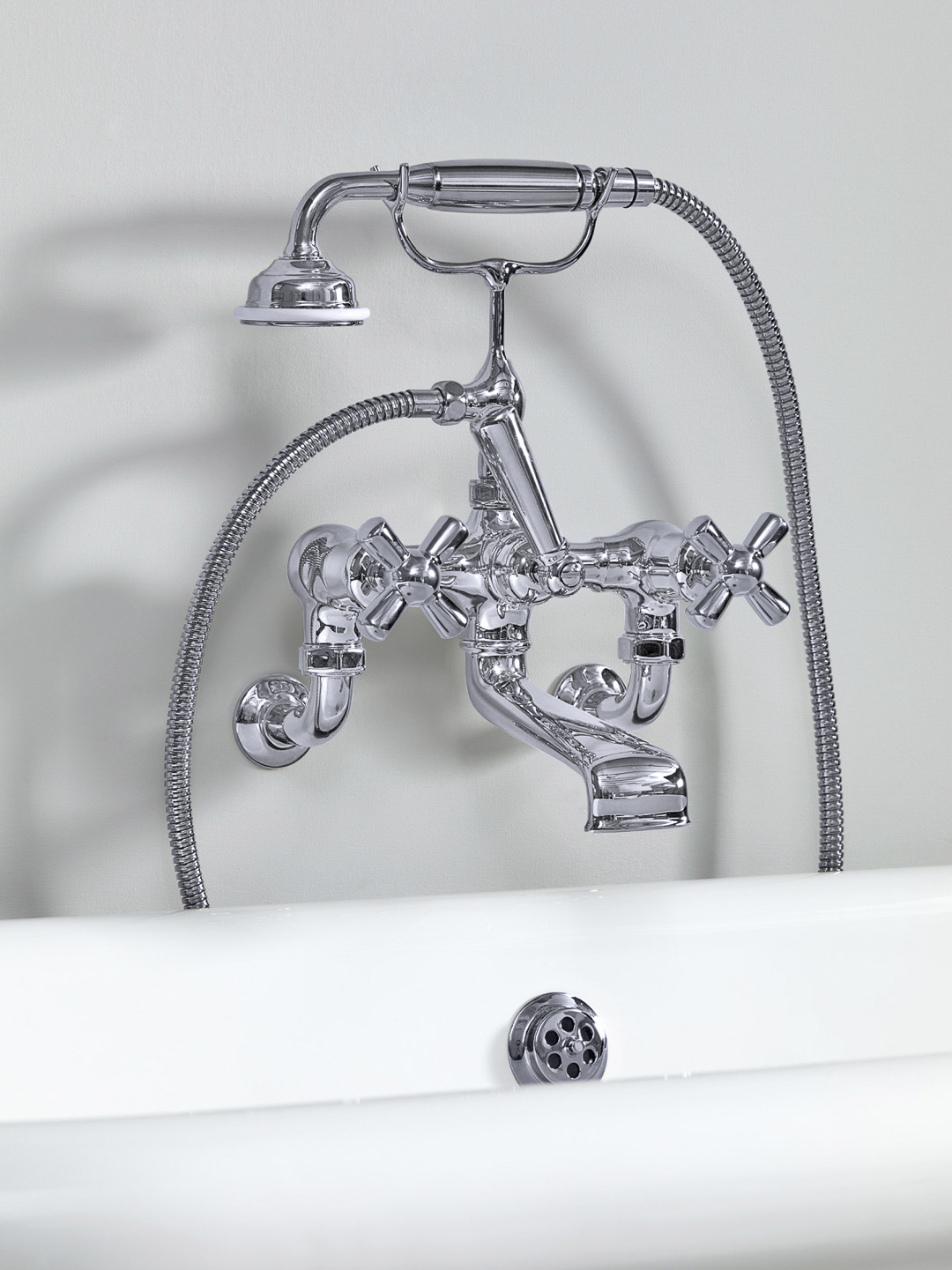 Rockwell wall-mounted bath mixer with handshower & metal/coloured crosshead taps