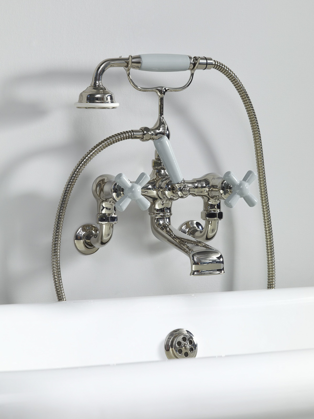 Rockwell wall-mounted bath mixer with handshower & metal/coloured crosshead taps